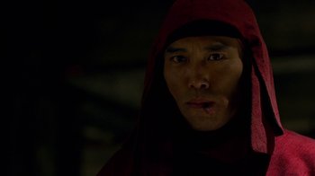 Movie still from “Daredevil” (2015), created by Drew Goddard – A man in a red robe and a black hood; Close Up shot, Over the shoulder angle