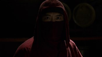 Movie still from “Daredevil” (2015), created by Drew Goddard – A man wearing a red robe and a red hood; Close Up shot, Over the shoulder angle