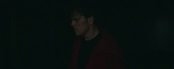Movie still from “The House That Jack Built” (2018), directed by Lars von Trier – A man wearing a red jacket standing in the dark; Medium shot, Low angle