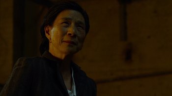 Movie still from “Daredevil” (2015), created by Drew Goddard – An older woman is standing in the dark; Close Up shot, Low angle