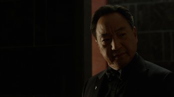 Movie still from “Daredevil” (2015), created by Drew Goddard – An older man in a black shirt and a black tie; Close Up shot, Over the shoulder angle