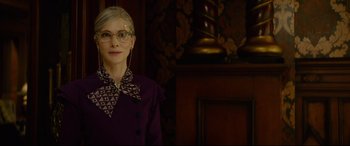 Movie still from “The House with a Clock in Its Walls” (2018), directed by Eli Roth – A woman wearing glasses and a purple dress; Close Up shot, Low angle