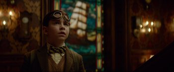 Movie still from “The House with a Clock in Its Walls” (2018), directed by Eli Roth – A young boy wearing a suit and tie and goggles; Close Up shot, Low angle