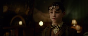 Movie still from “The House with a Clock in Its Walls” (2018), directed by Eli Roth – A young boy wearing goggles and a bow tie; Close Up shot, Over the shoulder angle