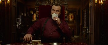 Movie still from “The House with a Clock in Its Walls” (2018), directed by Eli Roth – A man sitting in a chair holding a bunch of money; Medium shot, Over the shoulder angle
