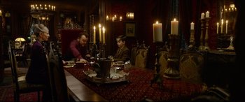 Movie still from “The House with a Clock in Its Walls” (2018), directed by Eli Roth – Two men are sitting at a table with candles on it; Medium shot, Over the shoulder angle
