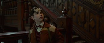 Movie still from “The House with a Clock in Its Walls” (2018), directed by Eli Roth – A young boy wearing a jacket and a bow tie; Medium shot, Low angle