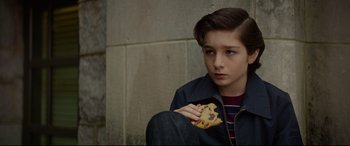 Movie still from “The House with a Clock in Its Walls” (2018), directed by Eli Roth – A young boy holding a piece of food in front of his face; Close Up shot, High angle