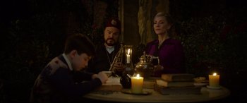 Movie still from “The House with a Clock in Its Walls” (2018), directed by Eli Roth – A family sitting at a dinner table with candles; Medium shot, Over the shoulder angle
