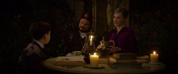 Movie still from “The House with a Clock in Its Walls” (2018), directed by Eli Roth – A man and a woman sitting at a table; Medium shot, Over the shoulder angle