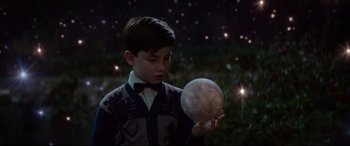 Movie still from “The House with a Clock in Its Walls” (2018), directed by Eli Roth – A young boy holding an object in front of a field; Medium shot, High angle
