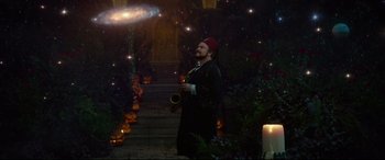 Movie still from “The House with a Clock in Its Walls” (2018), directed by Eli Roth – A man with a red hat is playing a saxophone; Wide shot, High angle
