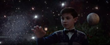 Movie still from “The House with a Clock in Its Walls” (2018), directed by Eli Roth – A young boy holding his hands out to the stars; Medium shot, Low angle