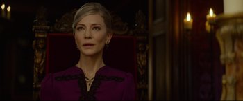 Movie still from “The House with a Clock in Its Walls” (2018), directed by Eli Roth – A woman in a purple dress sitting in a red chair; Close Up shot, Over the shoulder angle