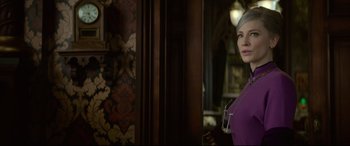 Movie still from “The House with a Clock in Its Walls” (2018), directed by Eli Roth – A woman standing in a room holding a wine glass; Medium shot, Over the shoulder angle