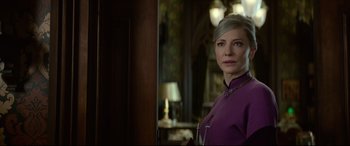Movie still from “The House with a Clock in Its Walls” (2018), directed by Eli Roth – A woman in a purple dress standing in front of a mirror; Close Up shot, Over the shoulder angle