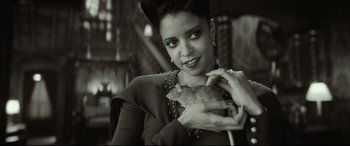 Movie still from “The House with a Clock in Its Walls” (2018), directed by Eli Roth – A black and white photo of a woman holding a piece of food; Close Up shot, High angle