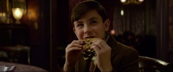Movie still from “The House with a Clock in Its Walls” (2018), directed by Eli Roth – A young boy is eating a sandwich with his hands; Close Up shot, Over the shoulder angle