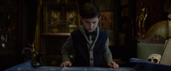 Movie still from “The House with a Clock in Its Walls” (2018), directed by Eli Roth – A young boy is looking down at a book; Medium shot, Low angle