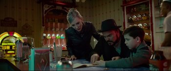 Movie still from “The House with a Clock in Its Walls” (2018), directed by Eli Roth – A man and a woman looking at papers on a table; Medium shot, Over the shoulder angle