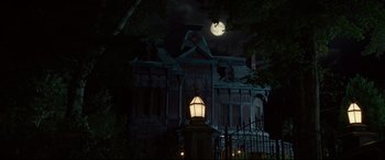 Movie still from “The House with a Clock in Its Walls” (2018), directed by Eli Roth – A house that is lit up at night with a full moon in the background; Extreme Wide shot, Low angle
