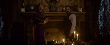 Movie still from “The House with a Clock in Its Walls” (2018), directed by Eli Roth – A man and a woman standing in front of candles; Medium shot, Low angle