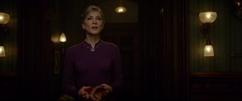 Movie still from “The House with a Clock in Its Walls” (2018), directed by Eli Roth – A woman standing in a dark room holding a purse; Medium shot, Over the shoulder angle
