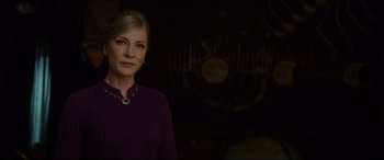 Movie still from “The House with a Clock in Its Walls” (2018), directed by Eli Roth – A woman standing in a dark room wearing a purple dress; Close Up shot, Over the shoulder angle
