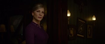 Movie still from “The House with a Clock in Its Walls” (2018), directed by Eli Roth – A woman in a purple sweater standing in front of a lamp; Close Up shot, Over the shoulder angle