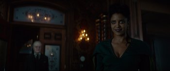 Movie still from “The House with a Clock in Its Walls” (2018), directed by Eli Roth – A woman standing in front of a wall with lights on it; Medium shot, Over the shoulder angle