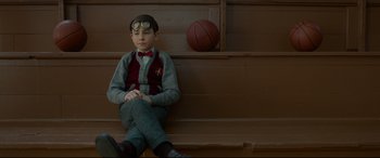 Movie still from “The House with a Clock in Its Walls” (2018), directed by Eli Roth – A boy sitting on a bench next to a basketball; Medium shot, Low angle