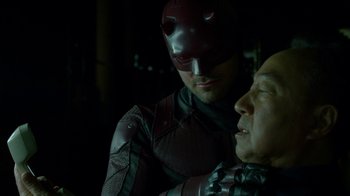 Movie still from “Daredevil” (2015), created by Drew Goddard – A man and a woman in a dark room; Close Up shot, Over the shoulder angle