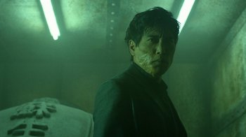 Movie still from “Daredevil” (2015), created by Drew Goddard – A man in a suit standing in a dark room; Close Up shot, Low angle