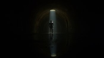 Movie still from “Daredevil” (2015), created by Drew Goddard – A man standing in the light of an underground tunnel; Extreme Wide shot, Low angle