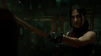 Movie still from “Daredevil” (2015), created by Drew Goddard – A person holding a sword in a room; Close Up shot, Over the shoulder angle