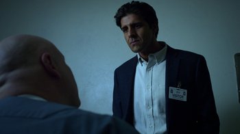 Movie still from “Daredevil” (2015), created by Drew Goddard – A man in a suit and tie standing in front of a mirror; Medium shot, Over the shoulder angle