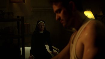 Movie still from “Daredevil” (2015), created by Drew Goddard – A man and a nun in a dark room; Medium shot, Over the shoulder angle
