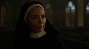 Movie still from “Daredevil” (2015), created by Drew Goddard – A woman wearing a nun's outfit and looking at the camera; Close Up shot, Over the shoulder angle