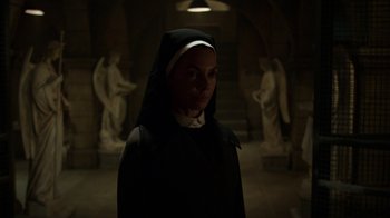 Movie still from “Daredevil” (2015), created by Drew Goddard – A woman in a nun's outfit standing in a dark room; Medium shot, High angle