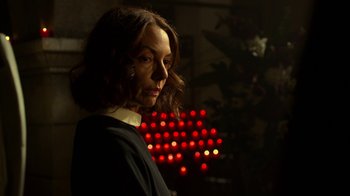 Movie still from “Daredevil” (2015), created by Drew Goddard – A woman is standing in front of some lights; Close Up shot, Low angle