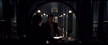Movie still from “Dark City” (1998), directed by Alex Proyas – A man in a suit is looking in the mirror; Medium shot, Low angle