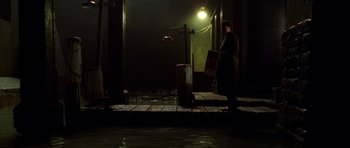 Movie still from “Dark City” (1998), directed by Alex Proyas – A person standing on a dock at night; Wide shot, Low angle