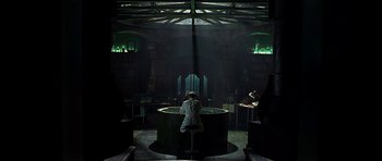 Movie still from “Dark City” (1998), directed by Alex Proyas – A man sitting in a large tub in a dark room; Wide shot, High angle