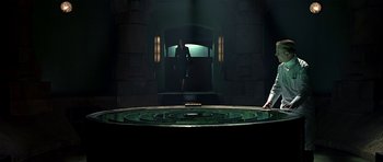 Movie still from “Dark City” (1998), directed by Alex Proyas – A man and a woman standing in front of an entrance to a building; Wide shot, High angle