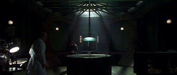 Movie still from “Dark City” (1998), directed by Alex Proyas – A woman is standing in a room with a large tub; Wide shot, High angle