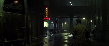Movie still from “Dark City” (1998), directed by Alex Proyas – People walking down a street at night in the dark; Wide shot, Over the shoulder angle