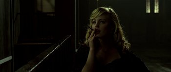 Movie still from “Dark City” (1998), directed by Alex Proyas – A beautiful blonde woman smoking a cigarette in the dark; Close Up shot, Low angle