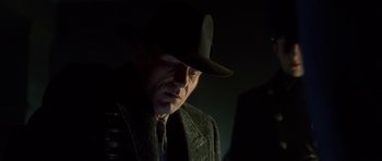 Movie still from “Dark City” (1998), directed by Alex Proyas – A man wearing a hat and a jacket; Close Up shot, Low angle