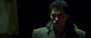 Movie still from “Dark City” (1998), directed by Alex Proyas – A person wearing a jacket; Close Up shot, Over the shoulder angle