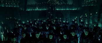 Movie still from “Dark City” (1998), directed by Alex Proyas – A large group of people in a dark room; Wide shot, High angle